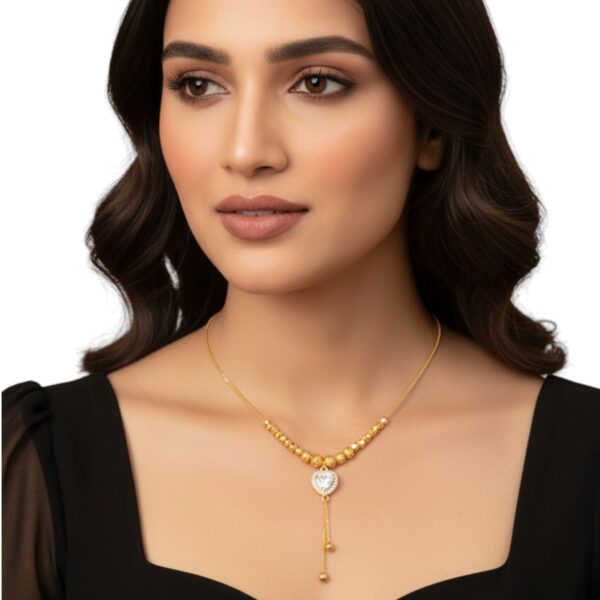 Close-up of RAGNISH Luxury Gold Beaded Chain and Drip Heart Pendant worn by model.