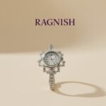 RAGNISH luxury sterling silver bangle watch with starburst cubic zirconia cluster setting and white analog dial on a neutral background.