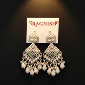 RAGNISH luxury pearl and kundan dangler earrings on white card against black background.