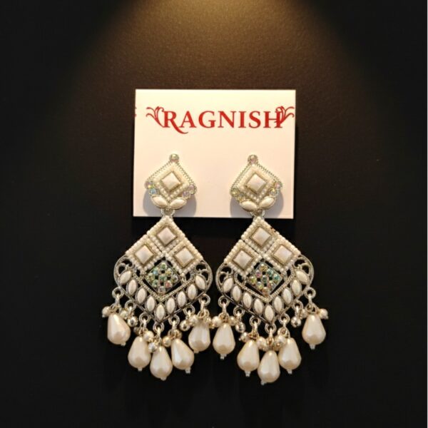 RAGNISH luxury pearl and kundan dangler earrings on white card against black background.