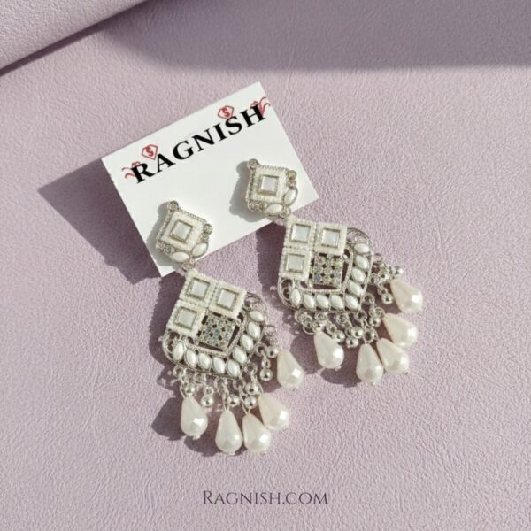 Silver-toned fashion jewelry: rhombus-shaped danglers with white faux pearls and clear Kundan stones.