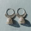 Close-up of RAGNISH Nitya bell-shaped Jhumka earrings with intricate silver detail and hoop closure.
