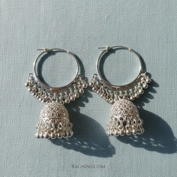 Close-up of RAGNISH Nitya bell-shaped Jhumka earrings with intricate silver detail and hoop closure.