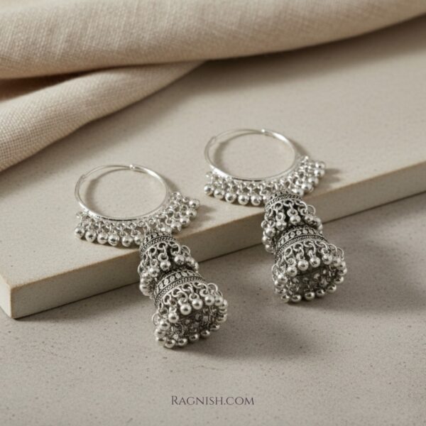RAGNISH Azmar Oxidized Silver Jhumka Hoop Earrings on matte beige background, high-angle product shot.