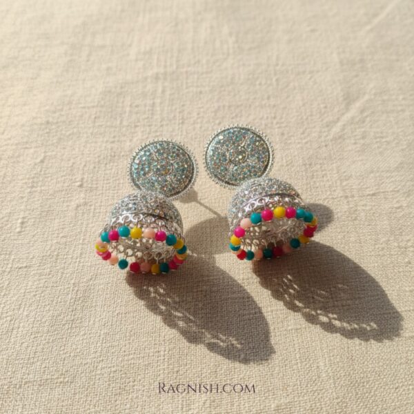 Close-up of rhinestone-studded bell earrings with a vibrant multicolor bead fringe.