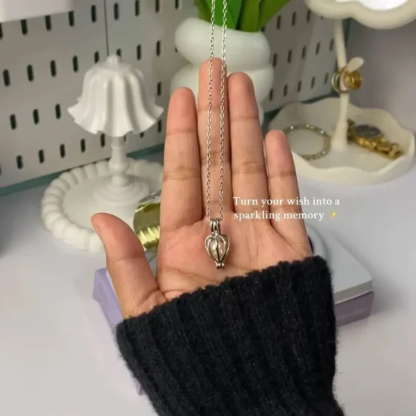 pearl cage pendant necklace with pearl jewelry holding in hand